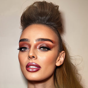 Woman with high hair and dramatic makeup.